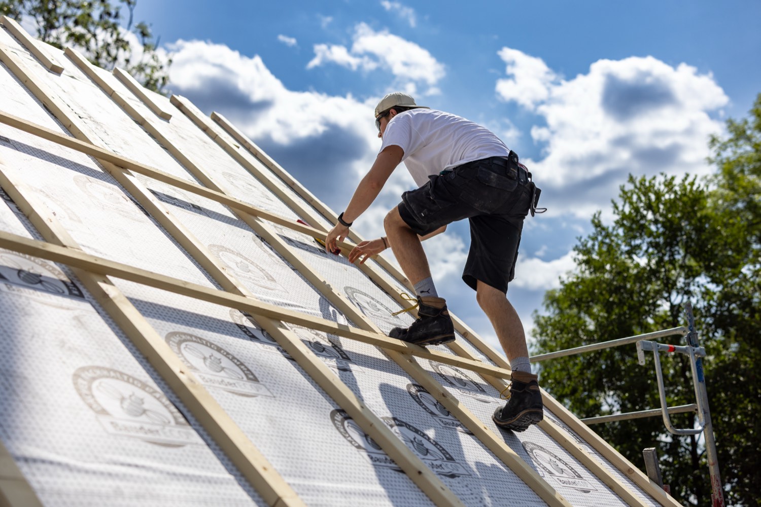 Zwei Zimmerer errichten einen Dachstuhl aus Holz